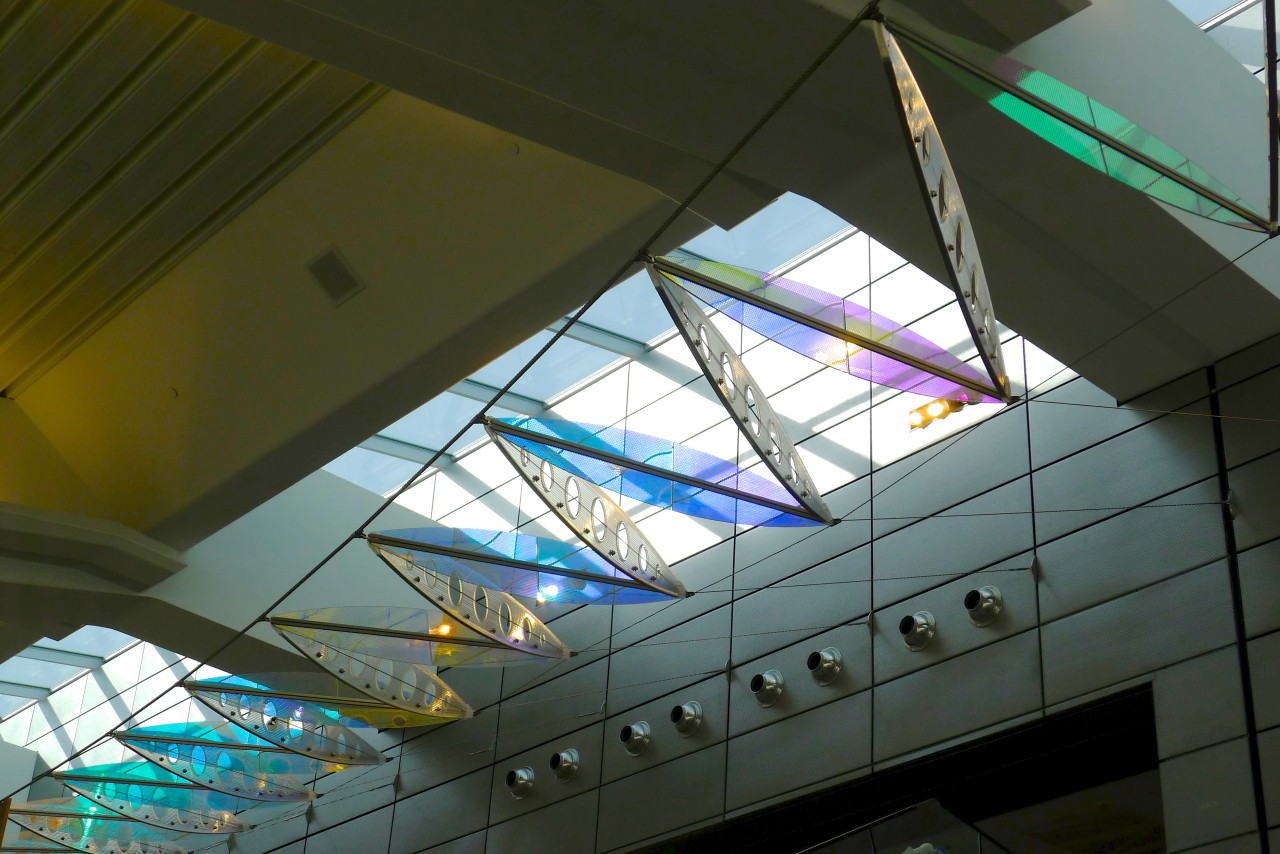 Ed Carpenter’s Wichita Dwight D. Eisenhower National Airport signature sculpture Aloft delights travelers with colorful laminated safety dichroic glass above. | Image 10 | Ed Carpenter, Artist
